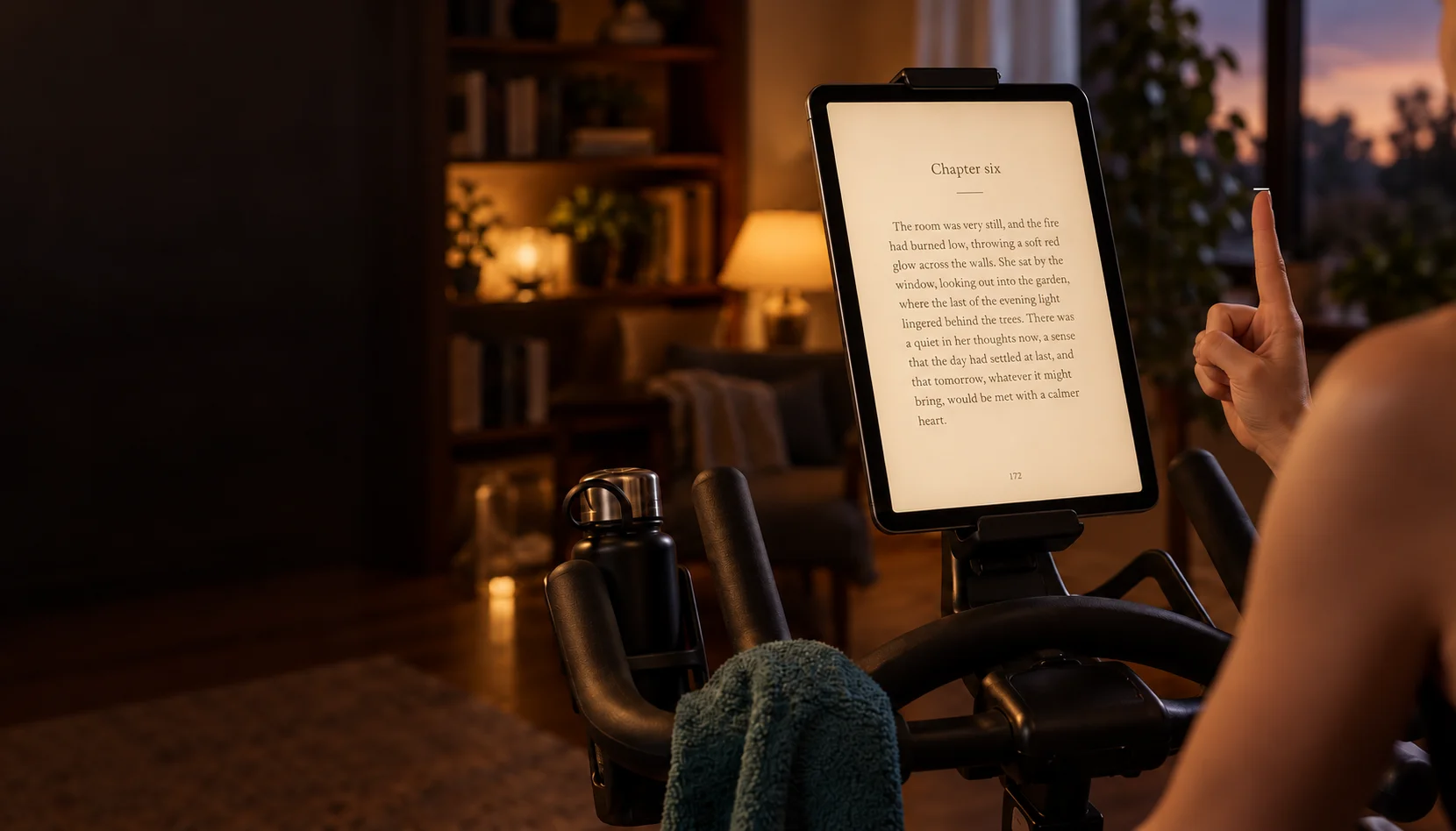 A portrait tablet mounted on an exercise bike, with a raised index finger beside it